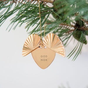 Gullfarget julepynt med hjerte og vingeformede detaljer, gravert med teksten «GOD NOK».